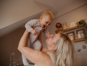 Mother holding baby in the air 