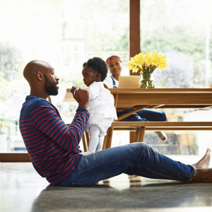 father and daughter playing with mother in the background