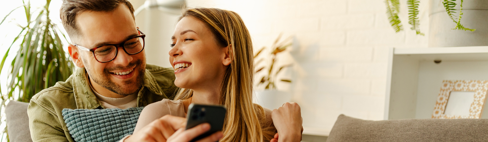 Couple looking at their mobile phone smiling
