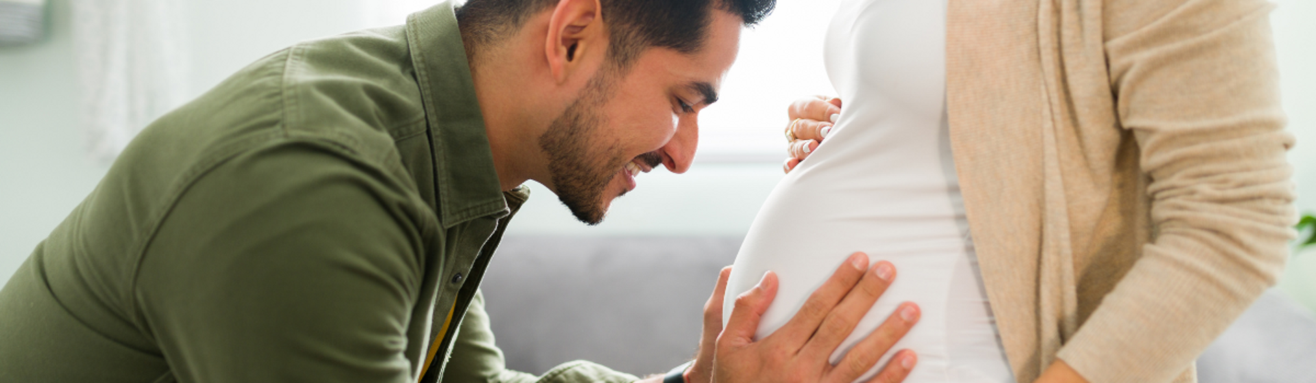 Man hugging womans pregnant stomach