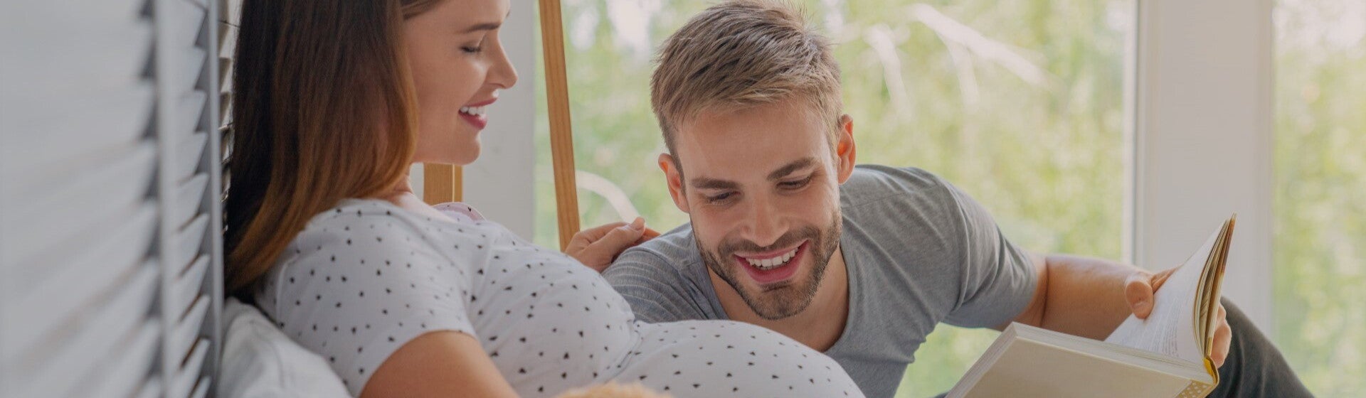 dad reading book to pregnant woman
